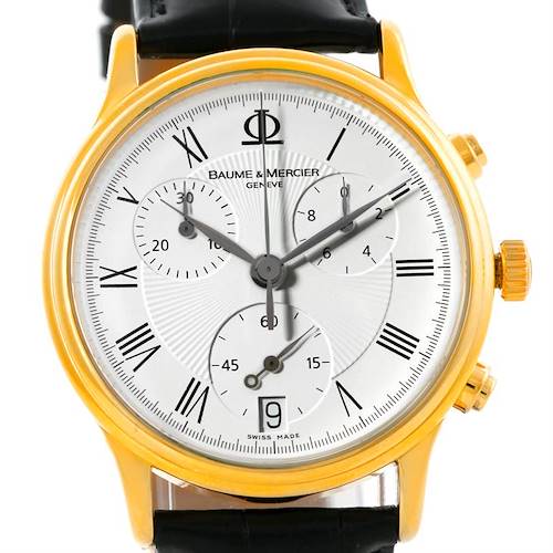 The image shows a Baume & Mercier Classima Men's Yellow Gold White Dial Men's Yellow Gold White Dial watch, frontal view, displaying its dial, subdials, Roman numerals, and gold-colored bezel.