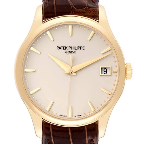 This image shows a Patek Philippe Calatrava 5227J Men's Yellow Gold White Dial 5227J Men's Yellow Gold White Dial watch face, crown, and part of the leather strap at a straight-on angle.